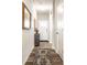 Elegant hallway with wood floors, decorative chest, and stylish rug leading to the front door at 2675 Cottage Ct, Brownsburg, IN 46112
