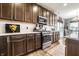 Bright kitchen features a stainless steel range, dark wood cabinetry, and a white subway tile backsplash at 2675 Cottage Ct, Brownsburg, IN 46112