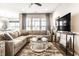 Comfortable living room with a plush sectional sofa, decorative pillows, and large windows providing ample light at 2675 Cottage Ct, Brownsburg, IN 46112