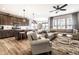 Open-concept living room flowing into the kitchen, featuring hardwood floors, a ceiling fan, and natural light at 2675 Cottage Ct, Brownsburg, IN 46112