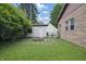 Cozy backyard featuring a charming brick fire pit, detached garage, and a partially fenced yard at 309 Poplar Rd, Indianapolis, IN 46219