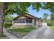 Charming single-story home with a brick facade and a long driveway leading to a detached garage at 309 Poplar Rd, Indianapolis, IN 46219