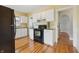 Kitchen featuring white cabinets, black appliances, and hardwood floors at 309 Poplar Rd, Indianapolis, IN 46219