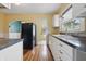 Cozy kitchen features hardwood floors, ample cabinet space, and a black refrigerator at 309 Poplar Rd, Indianapolis, IN 46219