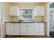 Kitchen features white cabinets, stainless steel sink and tile countertop at 309 Poplar Rd, Indianapolis, IN 46219