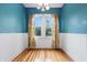 A bright room with blue walls and white trim showcases lovely hardwood flooring and natural light at 309 Poplar Rd, Indianapolis, IN 46219