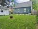 Home's backyard features grass lawn, home exterior, and fire pit, providing outdoor space at 310 S Butler Ave, Indianapolis, IN 46219