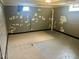Unfinished basement featuring a painted brick wall, a window for light, and a concrete floor with rugs at 310 S Butler Ave, Indianapolis, IN 46219