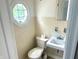 Cozy bathroom with classic fixtures, including toilet, sink, and an octagon window for natural light at 310 S Butler Ave, Indianapolis, IN 46219