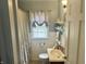Clean bathroom featuring wainscoting, a shower with curtain, and a vanity with a sink at 310 S Butler Ave, Indianapolis, IN 46219