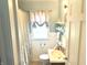 Cozy bathroom featuring vanity sink, beadboard, and a shower with floral curtain at 310 S Butler Ave, Indianapolis, IN 46219