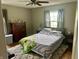Comfortable bedroom featuring a large window, neutral walls, and a cozy bed with a patterned quilt at 310 S Butler Ave, Indianapolis, IN 46219