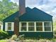 Charming home with a brick chimney, a yellow front door, and meticulously landscaped front yard at 310 S Butler Ave, Indianapolis, IN 46219