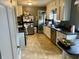 Well-lit kitchen featuring tile floors, white cabinetry, stainless steel appliances, and an eat-in area at 310 S Butler Ave, Indianapolis, IN 46219