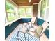Enclosed porch with beautiful windows and cozy seating on a blue and white rug at 310 S Butler Ave, Indianapolis, IN 46219