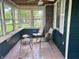 Enclosed sunroom featuring tiled floor, multiple windows, and comfortable seating at 310 S Butler Ave, Indianapolis, IN 46219