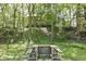 View of a wooded backyard with mature trees and a wooden picnic table set at 310 Wellington Overlook, Noblesville, IN 46060
