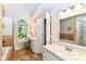 Bathroom featuring tile floors, double sink vanity, soaking tub, arched window, and natural light at 310 Wellington Overlook, Noblesville, IN 46060