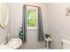 Well-lit bathroom with a decorative mirror, neutral walls, and a window with natural light at 310 Wellington Overlook, Noblesville, IN 46060