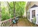 Back deck with chairs and table, railing, lush greenery, and exterior house view at 310 Wellington Overlook, Noblesville, IN 46060