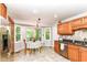 Charming kitchen with wood cabinets, stainless steel appliances, tile flooring, and a cozy breakfast nook at 310 Wellington Overlook, Noblesville, IN 46060
