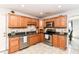 Functional kitchen featuring wood cabinets, stainless steel appliances, granite countertops, and a tile backsplash at 310 Wellington Overlook, Noblesville, IN 46060