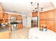 Inviting kitchen with wood cabinetry, stainless steel appliances, tile flooring, and a table for casual dining at 310 Wellington Overlook, Noblesville, IN 46060