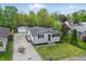 Aerial view of a single-Gathering home featuring a detached garage, mature trees, and well-maintained landscaping at 316 S Roena St, Indianapolis, IN 46241