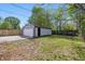 Spacious backyard featuring a detached garage, patchy grass, and a wood fence, perfect for outdoor activities at 316 S Roena St, Indianapolis, IN 46241