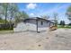 Rear exterior of the home, featuring a shed, wood ramp and large concrete driveway, surrounded by spring trees at 316 S Roena St, Indianapolis, IN 46241