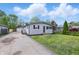 Charming home with manicured lawn, and a long driveway leading to a detached garage, perfect for Gathering living at 316 S Roena St, Indianapolis, IN 46241