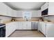 Updated kitchen with white cabinets, butcher block counters, stainless appliances, and wood-look floor at 316 S Roena St, Indianapolis, IN 46241