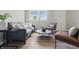 Bright living room with hardwood floors, gray sofa, comfortable chairs, and ample natural light at 316 S Roena St, Indianapolis, IN 46241