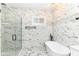 A newly renovated bathroom features a glass shower, marble tiling, and a tub at 3241 Ruckle St, Indianapolis, IN 46205