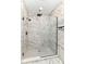 A newly renovated bathroom features a glass shower with beautiful marble tiling at 3241 Ruckle St, Indianapolis, IN 46205