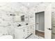 A newly renovated bathroom features a double vanity, marble tiling, and a glass shower at 3241 Ruckle St, Indianapolis, IN 46205