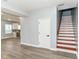Open-concept living space features gray walls, wood floors, a staircase and flows into the kitchen at 3241 Ruckle St, Indianapolis, IN 46205
