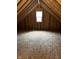Spacious unfinished attic with exposed rafters and a bright window creates potential for customization at 336 W 29Th St, Indianapolis, IN 46208