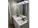 Bathroom vanity with white countertop, double sinks, black faucets and a large mirror with modern lighting at 336 W 29Th St, Indianapolis, IN 46208