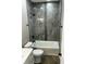 Modern bathroom featuring a tiled shower and bathtub with a sleek, black shower head and faucet at 336 W 29Th St, Indianapolis, IN 46208