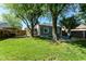 Landscaped backyard with lush lawn, a fire pit area, and an outdoor cooking station for entertaining at 3608 Valley Lake Dr, Indianapolis, IN 46227