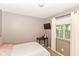 A neat bedroom featuring a mounted TV, a small desk, and a bright window at 3608 Valley Lake Dr, Indianapolis, IN 46227
