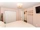 A well-lit bedroom with a closet, wall shelving, and light-colored walls at 3608 Valley Lake Dr, Indianapolis, IN 46227