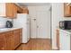 Functional kitchen with wood cabinets, white appliances, white countertops and wood laminate floors at 3937 Candle Berry Dr, Indianapolis, IN 46235