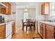 Eat-in kitchen features wood cabinets, white appliances, and a sunlit dining area with seating for six at 3937 Candle Berry Dr, Indianapolis, IN 46235