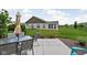 Large backyard with a concrete patio, a glass table, outdoor seating, and mature landscaping at 4034 Cairo Way, Avon, IN 46123