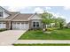 Charming brick home featuring a two-car garage, blue shutters, and a well-maintained lawn with landscaping at 4034 Cairo Way, Avon, IN 46123