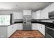 Spacious kitchen featuring white cabinets, stainless steel appliances, dark countertops and hardwood floors at 4034 Cairo Way, Avon, IN 46123