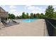 Community pool with lounge chairs, a fence, and lush green trees in the background at 4034 Cairo Way, Avon, IN 46123