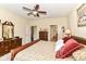 Spacious bedroom with a ceiling fan, wood furniture, and access to additional rooms at 4039 Amaryllis Dr, Plainfield, IN 46168